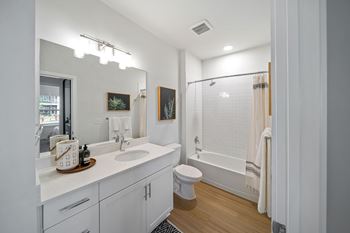 A white bathroom with a toilet, sink, and mirror.
